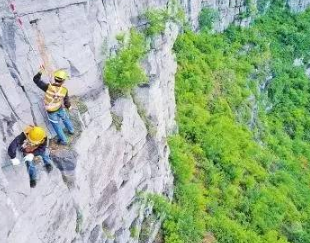 捅山工百米高空作業，為保障山下列車通行安全